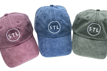 Three baseball caps in different colors with 'STL' logo on a white background